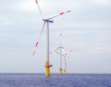 Three windmills at sea